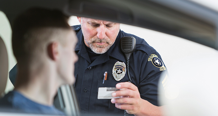 police officer checking ID of driver